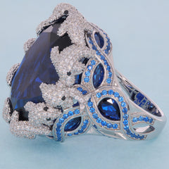 Oval blue sapphire sterling silver ring with intricate design and sparkling accents, showcasing luxury and elegance.