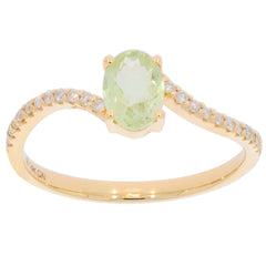 Oval green Peridot ring in 14K yellow gold with diamond accents, showcasing elegance and luxury.