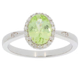Green Peridot ring in 14K white gold with diamond accents, showcasing an oval gemstone centerpiece and elegant design.