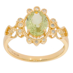 Oval green peridot 14K yellow gold ring with diamond accent, featuring an intricate floral design.