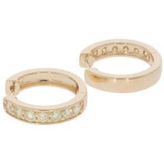 Round gold earrings with sparkling diamond accents, perfect for elegant styling and luxury. Ideal for sophisticated jewelry collections.