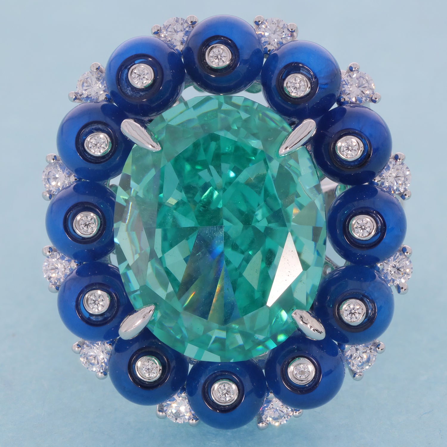 Cushion green moissanite sterling silver ring with blue accent gemstones, showcasing luxury and elegance.