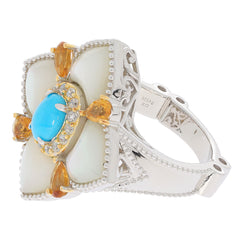 Blue turquoise and cabochon accented sterling silver ring with intricate design and sparkling gemstones.