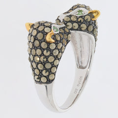 Unique silver ring featuring two owl heads embellished with sparkling black and green gemstones.
