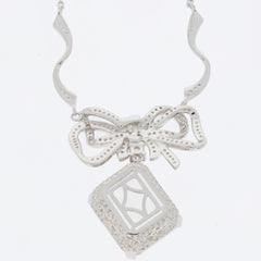Elegant sterling silver necklace with a bow design and a decorative diamond-shaped pendant.