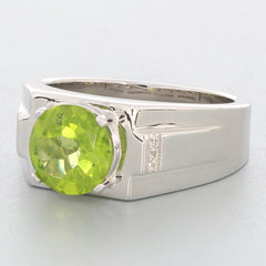 Round green peridot ring in sterling silver setting with accent stones, showcasing luxury and elegance.