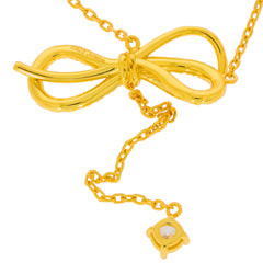 Elegant gold necklace featuring a bow design with a sparkling gemstone accent, perfect for stylish occasions.