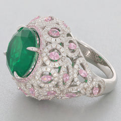 Round green emerald sterling silver ring with pink accents and intricate detailing, radiating elegance.