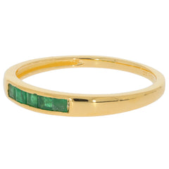 Elegant gold ring featuring green emerald accents for a luxurious touch.