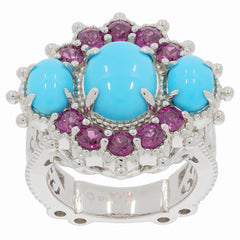 Oval blue turquoise ring with purple accent stones in sterling silver setting, showcasing vibrant elegance.