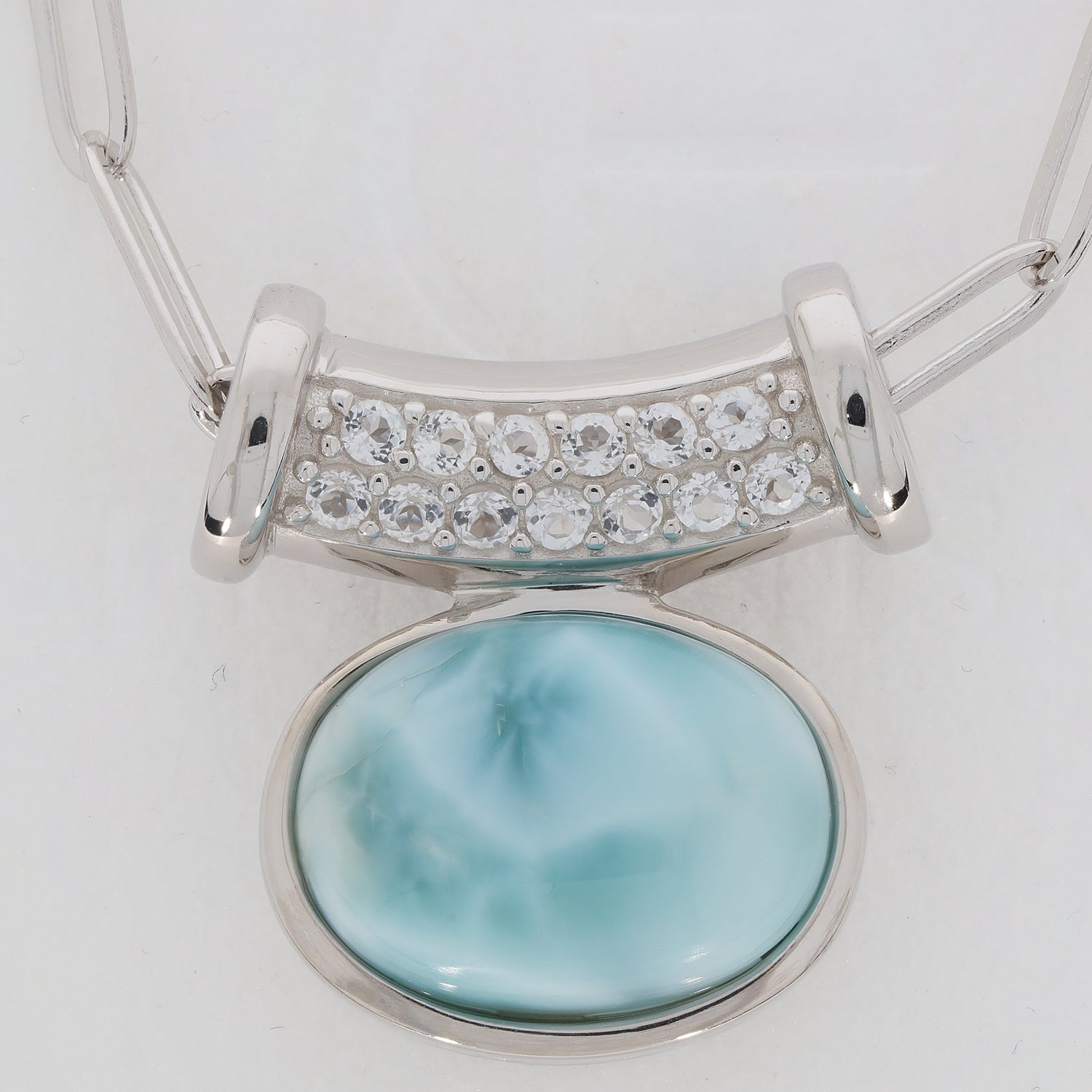 Oval blue Larimar Pectolite sterling silver pendant with sparkling gemstone accent, showcasing elegance and luxury.