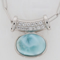 Oval blue Larimar Pectolite sterling silver pendant with sparkling gemstone accent, showcasing elegance and luxury.