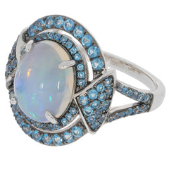 Elegant oval white opal sterling silver ring with sparkling blue gemstone accents.