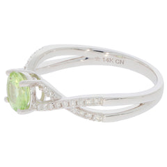 Elegant 14K white gold ring featuring a green peridot gemstone and diamond accents, perfect for a sophisticated look.