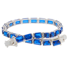Custom sterling silver semi mount tennis bracelet setting with vibrant blue emerald cut stones.