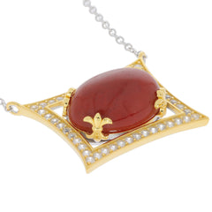 Oval red coral pendant set in gold, accented with sparkling gemstones and chain, showcasing luxurious elegance.