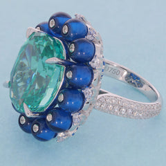 Cushion green moissanite ring with blue accents and silver band, showcasing luxury and elegance.