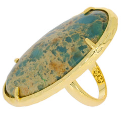 Oval blue turquoise sterling silver ring with gold accents, showcasing elegant design and sparkling gemstone.