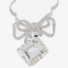 Elegant silver necklace with a bow design and a large square gemstone pendant.