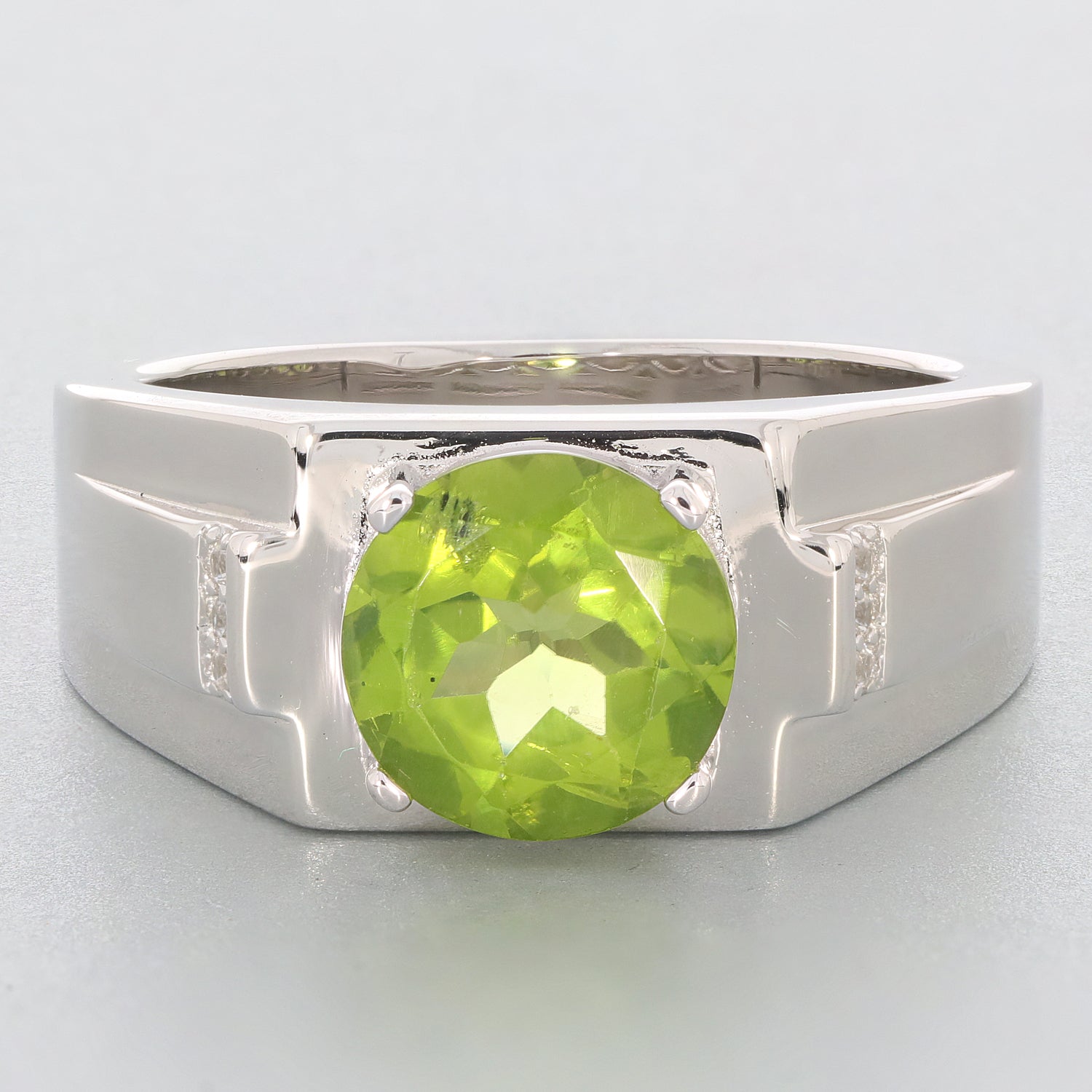 Round green peridot gemstone set in a sterling silver ring, showcasing elegant accents for a luxurious look.