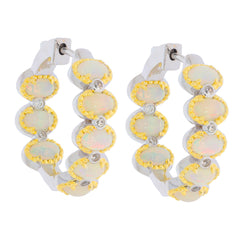 Sterling silver hoop earrings with opal stones and yellow gold accents, adding elegance to any outfit.