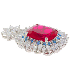 Red ruby gemstone pendant with sterling silver and blue accents, showcasing elegant design and sparkling brilliance.