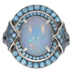 Oval white opal sterling silver ring accented with sparkling blue gemstones, showcasing timeless elegance.