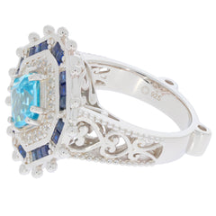 Emerald blue topaz sterling silver ring with accent stones, showcasing elegance and luxury in intricate design.