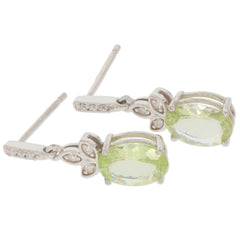 Elegant oval green peridot earrings in 14K white gold with sparkling diamond accents.