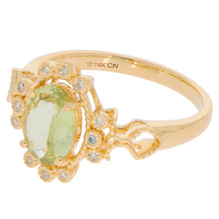 Oval green peridot ring in 14K yellow gold with diamond accents, showcasing elegant design and luxury.