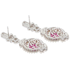 Oval red ruby sterling silver earrings with intricate design and moissanite accents, radiating elegance.