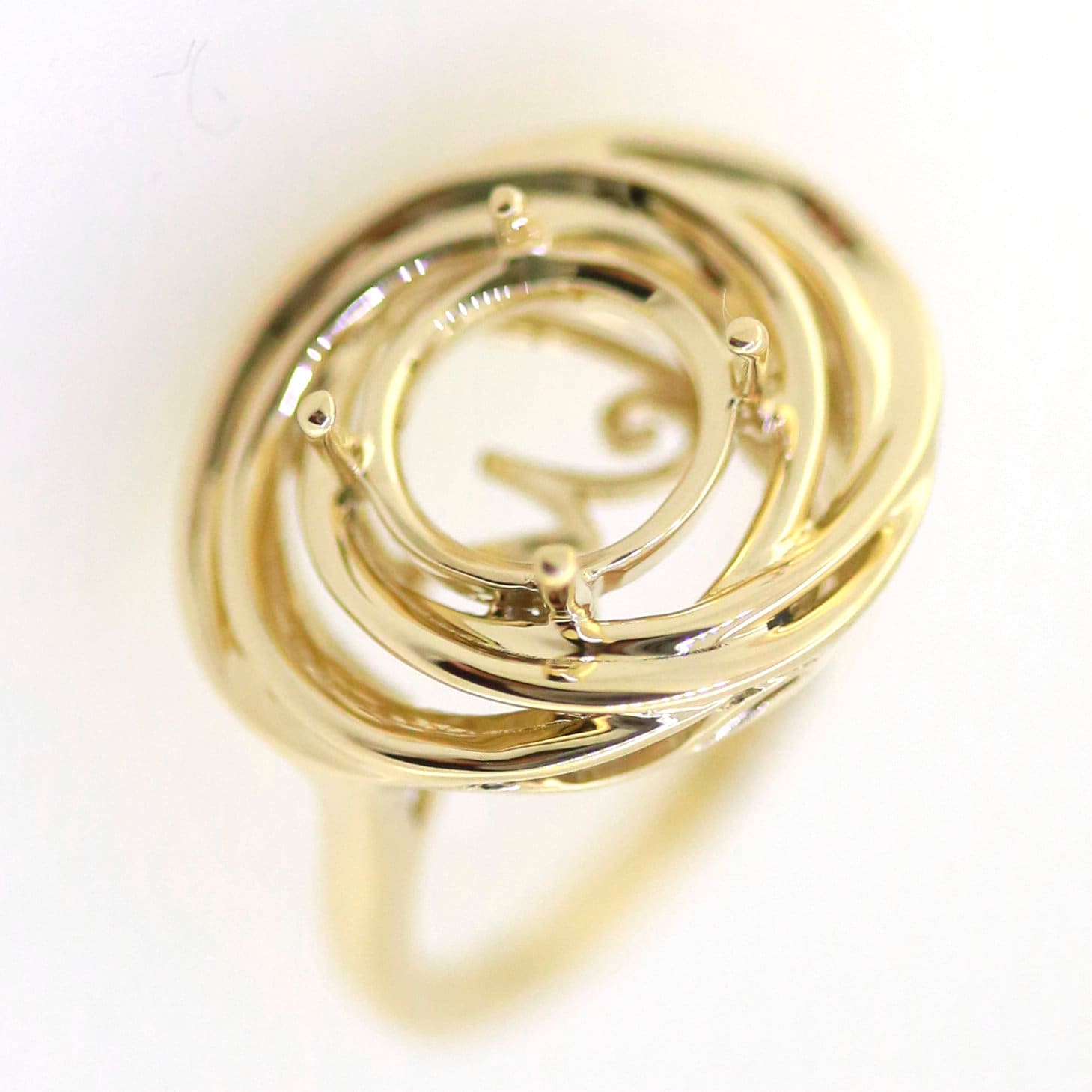 Elegant gold spiral ring design featuring a contemporary loop pattern, perfect for gemstone setting.