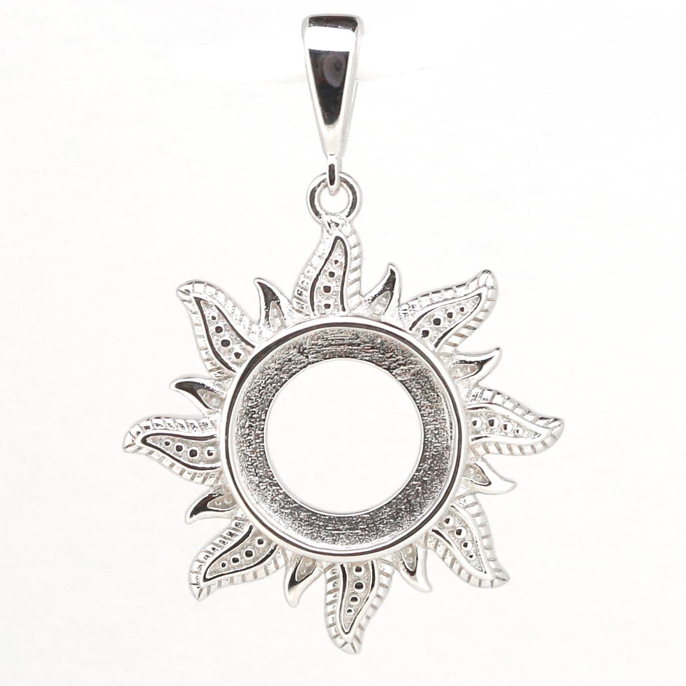 Sterling silver semi mount pendant setting featuring a decorative sun face design, 10x10mm cabochon slot.