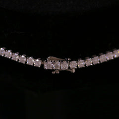 Close-up of a sterling silver semi mount tennis necklace setting with sparkling round gemstones.