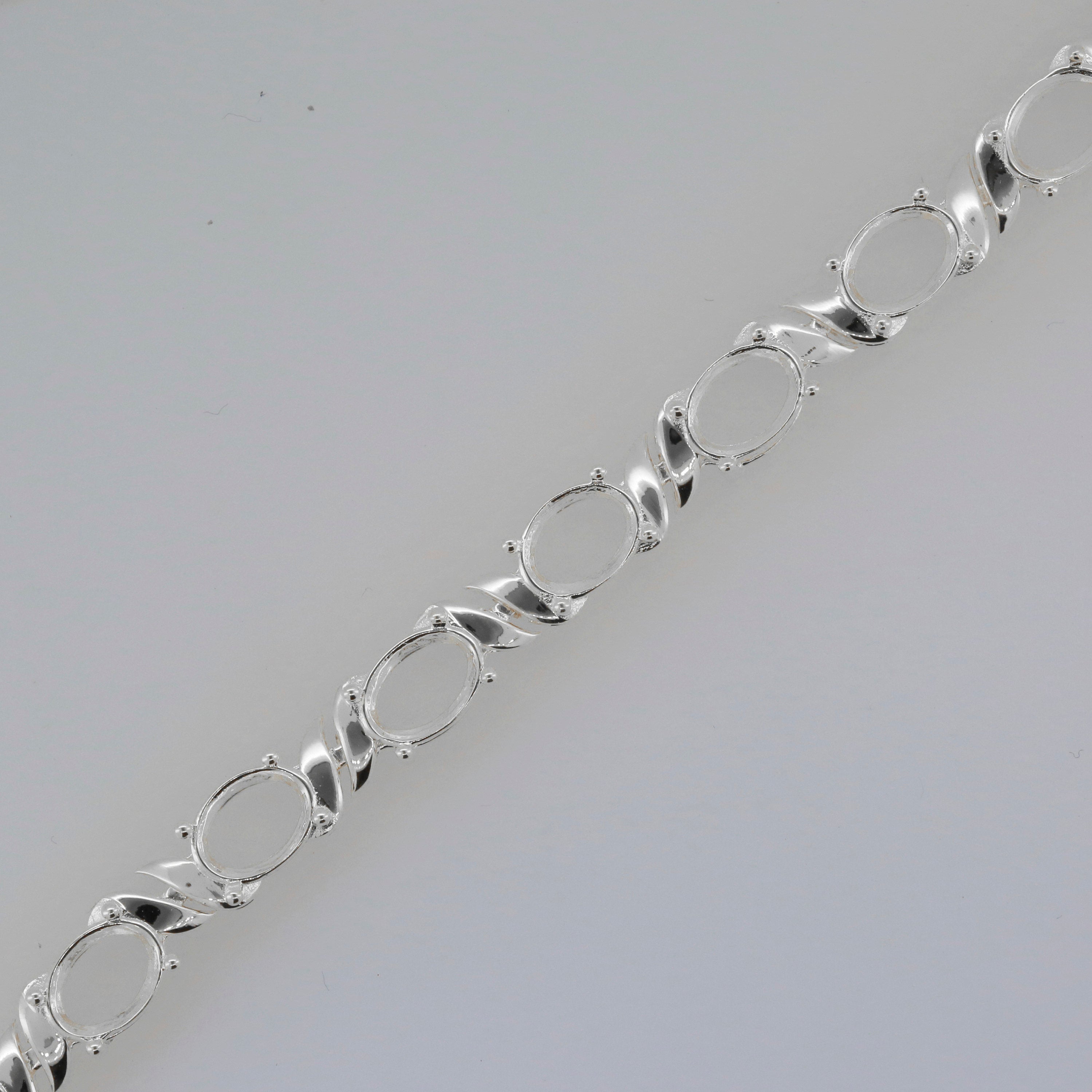 Sterling Silver Semi Mount Tennis Bracelet Setting with oval placeholders for 8x6mm gemstones.