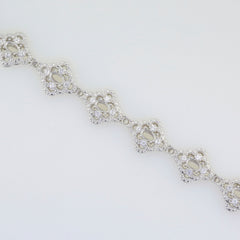 Sterling silver semi mount tennis bracelet setting with oval halo design and white topazstone placeholders.