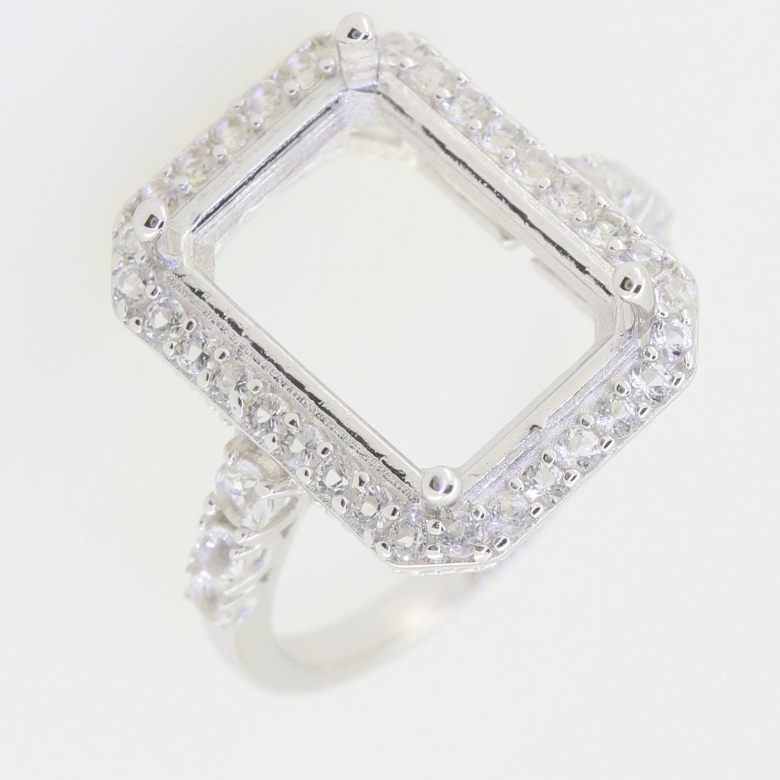 Sterling Silver semi mount ring setting with white topaz accents, designed for an emerald cut gemstone.