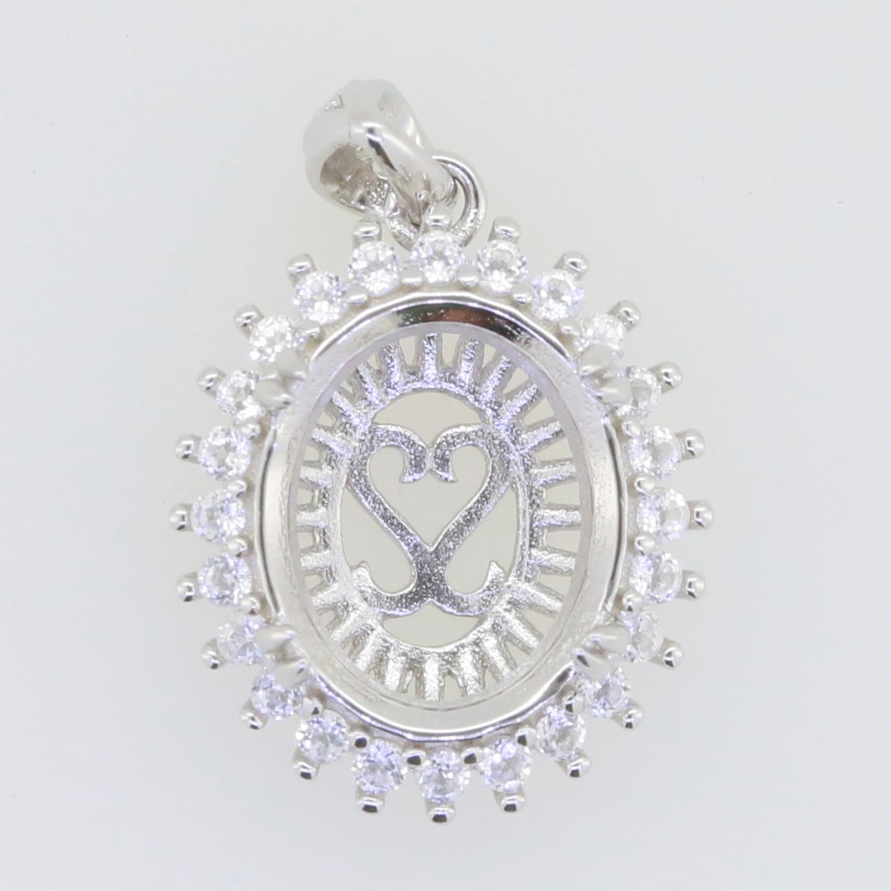 Sterling silver semi mount pendant setting with oval halo and white topaz accent, 12x10mm design for custom gemstones.