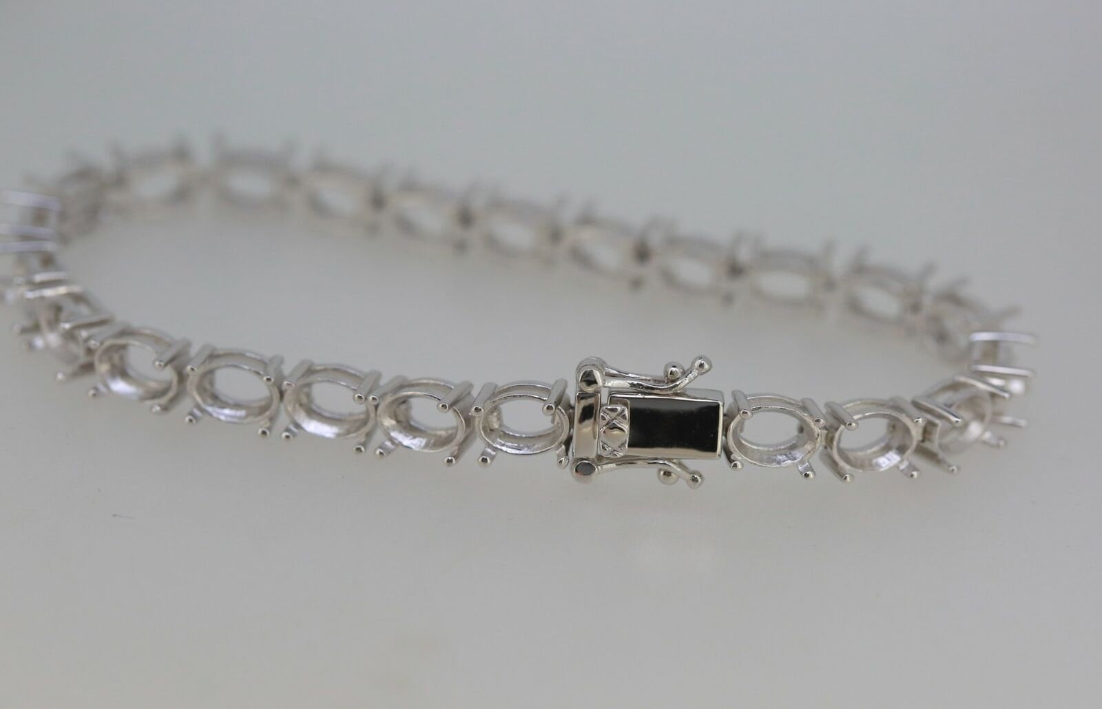 Sterling Silver Semi Mount Tennis Bracelet Setting with an oval slot for gemstone placement.