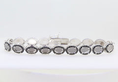 Sterling silver semi mount tennis bracelet setting with oval cabochon halo and black spinel accents.