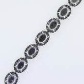 Sterling silver semi mount tennis bracelet setting with black spinel, featuring oval cabochons in a halo design.