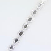 Sterling Silver semi mount tennis bracelet setting with oval cabochon halo and white topaz accents.