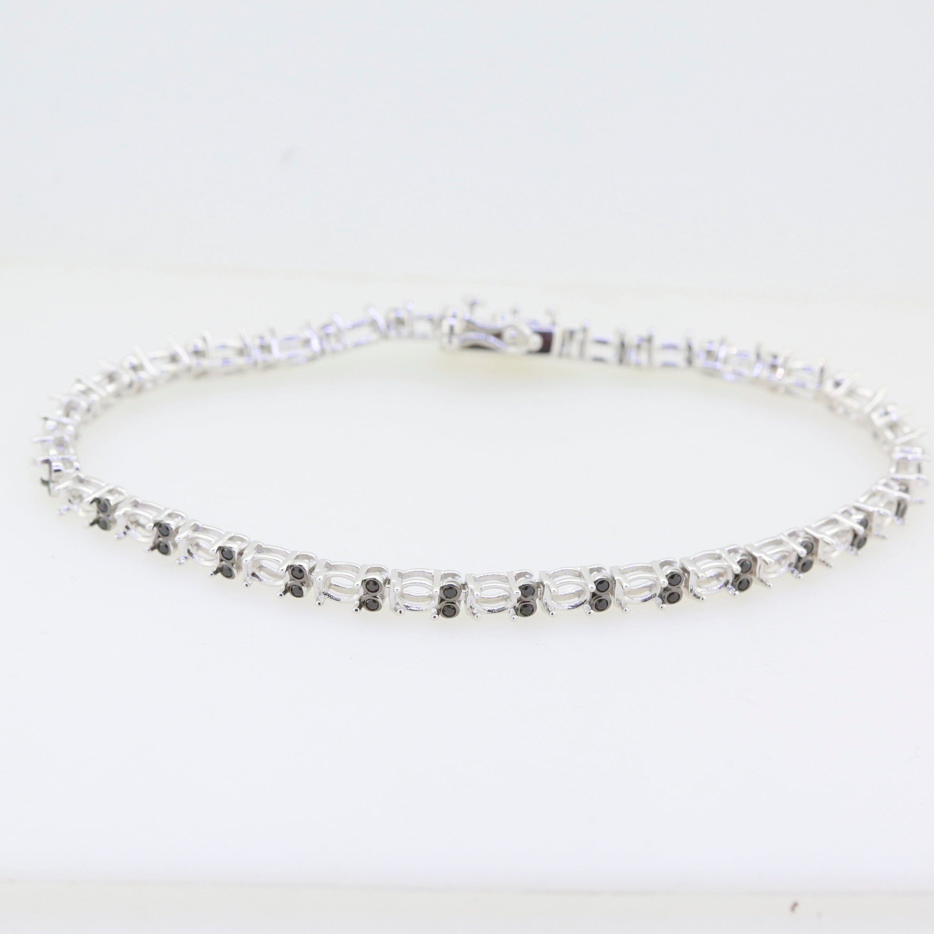Sterling silver semi mount tennis bracelet setting with black spinel accents, elegant design for customizable sizes.
