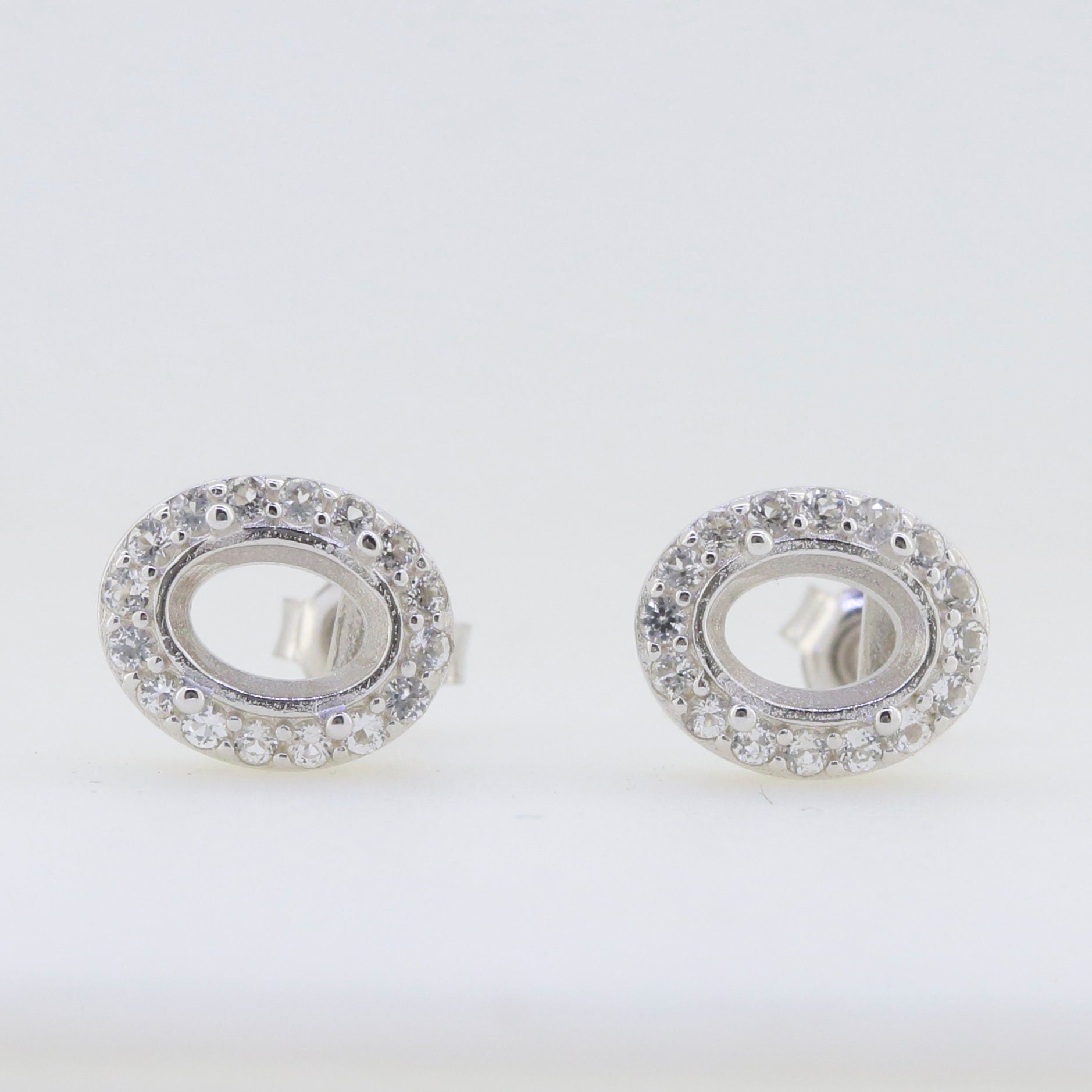 Sterling Silver semi mount earrings setting with oval shape, featuring sparkling white topaz gemstones.