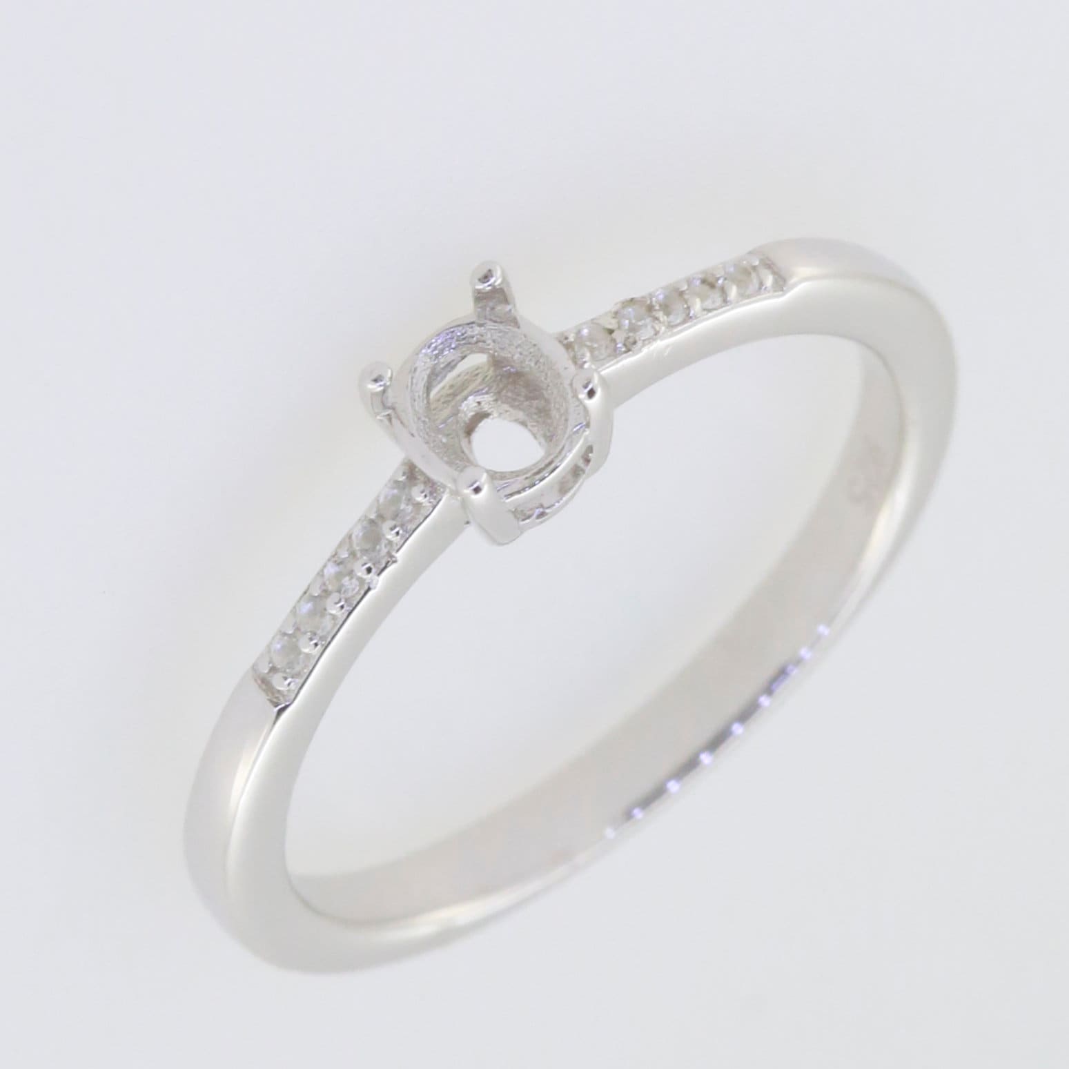 Sterling silver semi mount ring setting with oval halo and Moissanite accents, designed for customizable gemstone sizes.