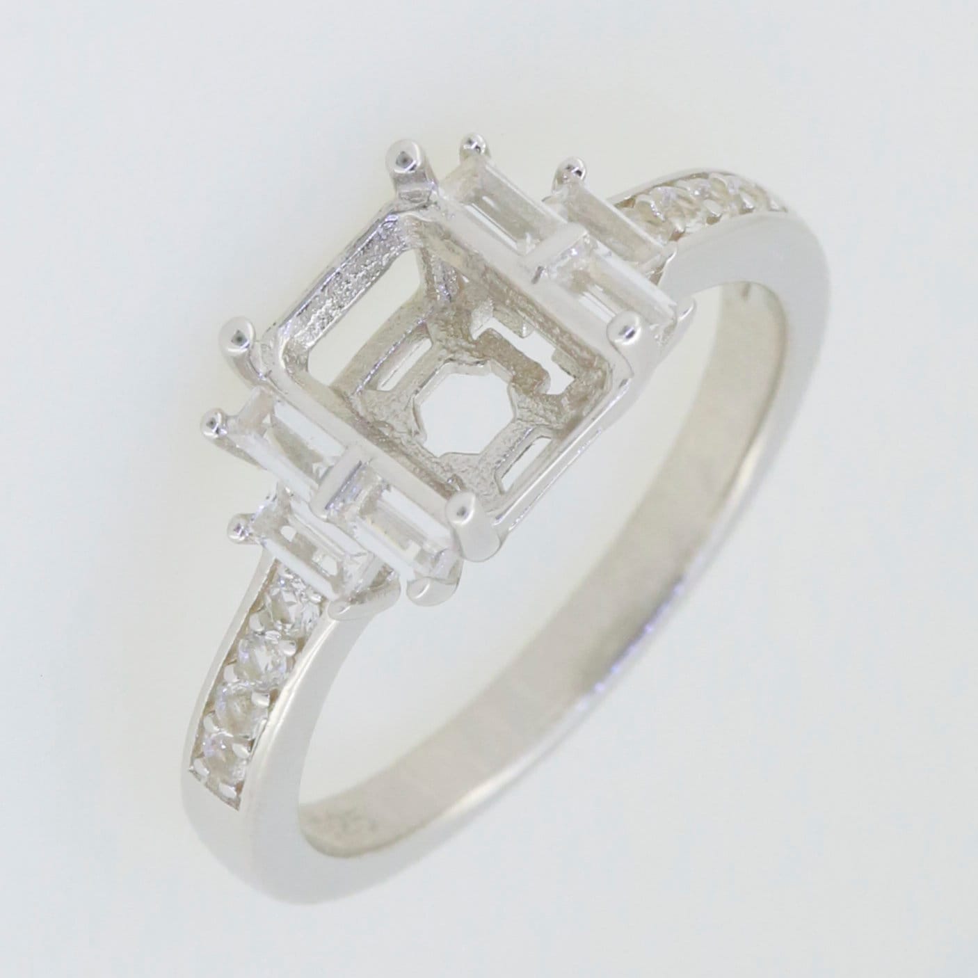 Sterling silver semi mount ring setting with white topaz accents, designed for an emerald cut gemstone.