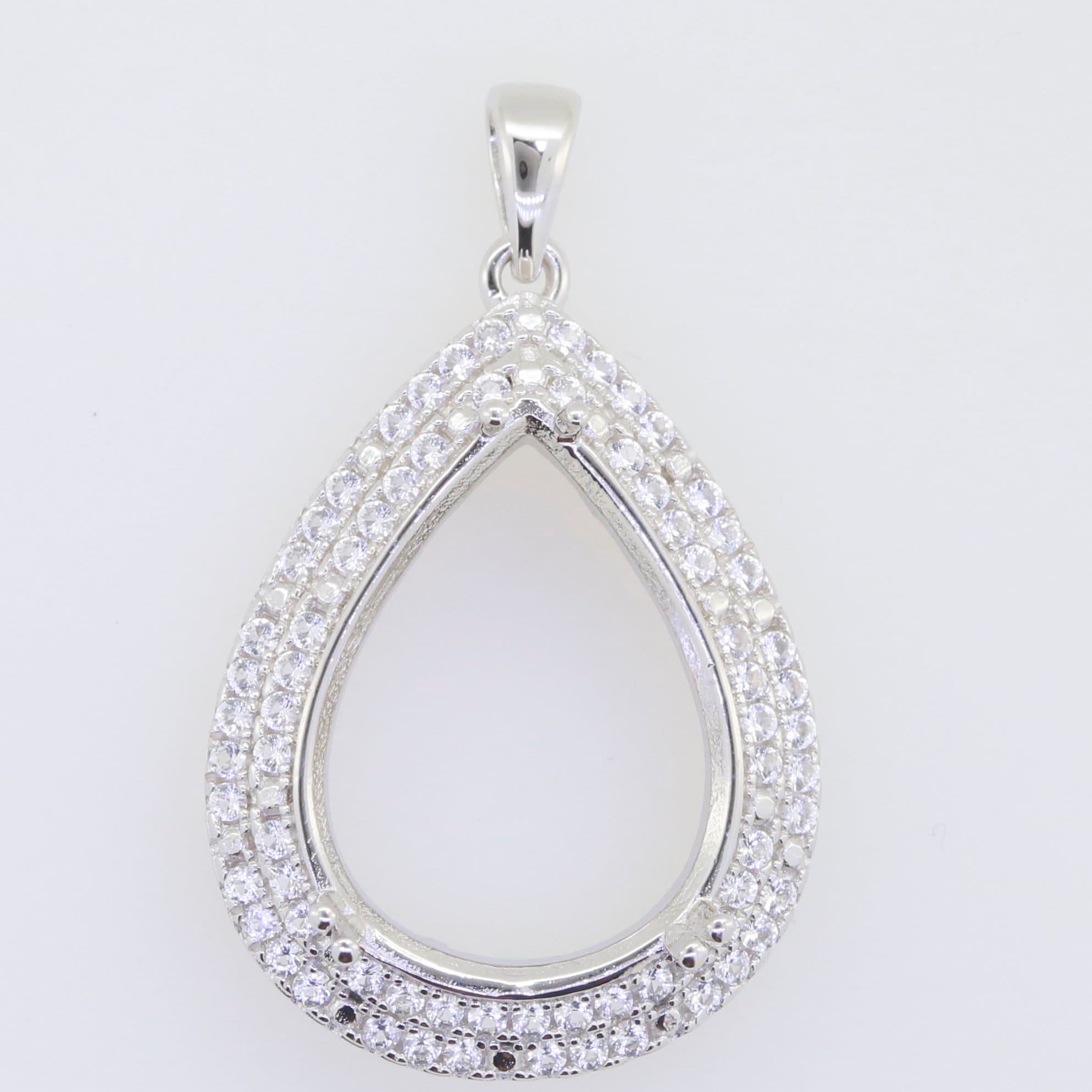 Sterling silver semi mount pendant setting in teardrop shape, adorned with sparkling white topaz gemstones.