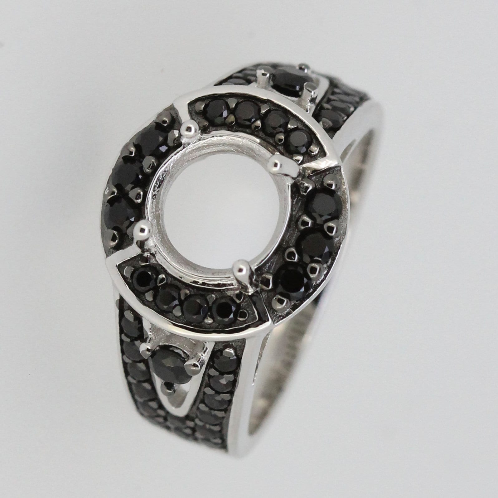 Sterling silver semi mount ring setting with round halo and black spinel accents, designed for custom gemstone fitting.
