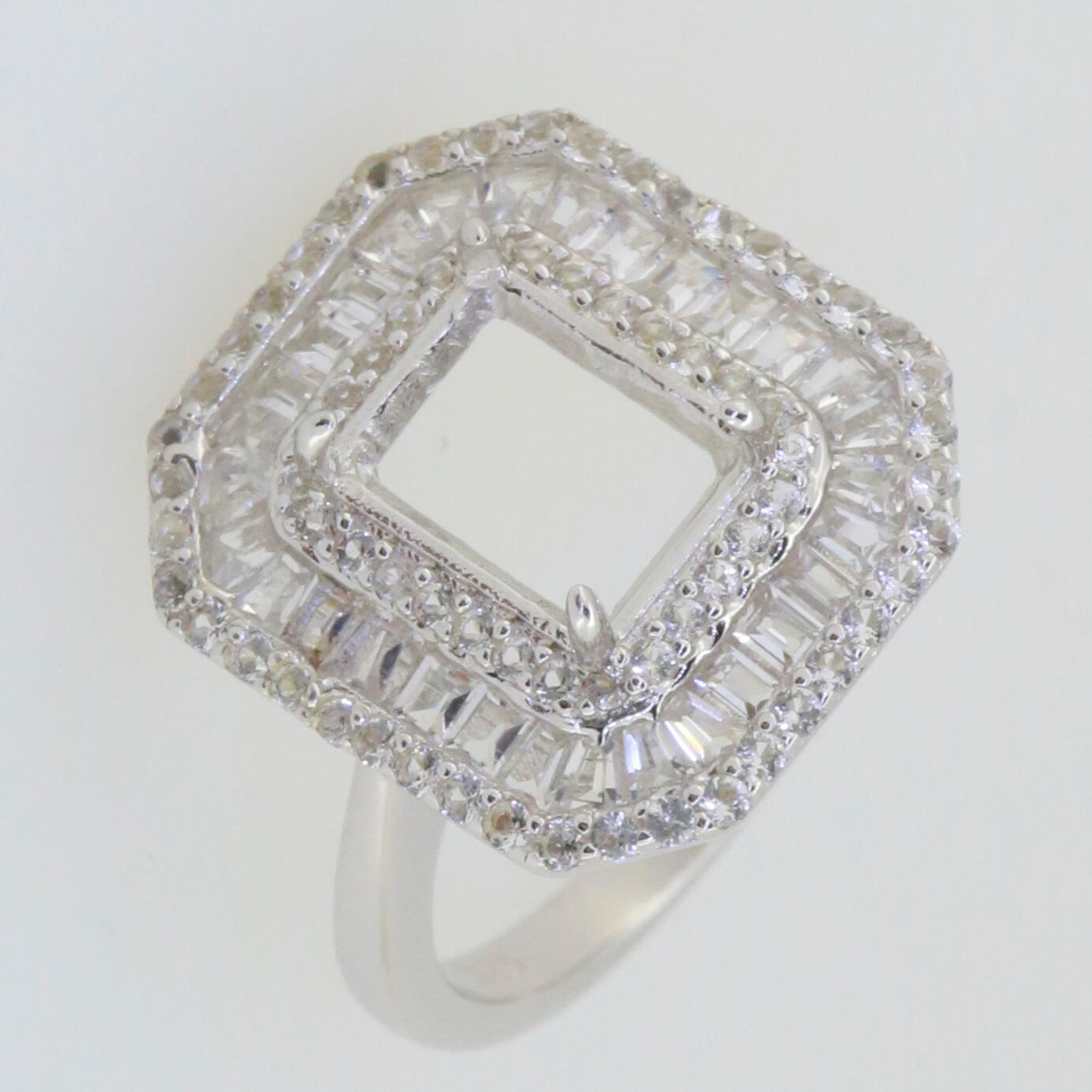 Sterling silver semi mount ring setting featuring baguette and halo design with clear topaz gemstones.