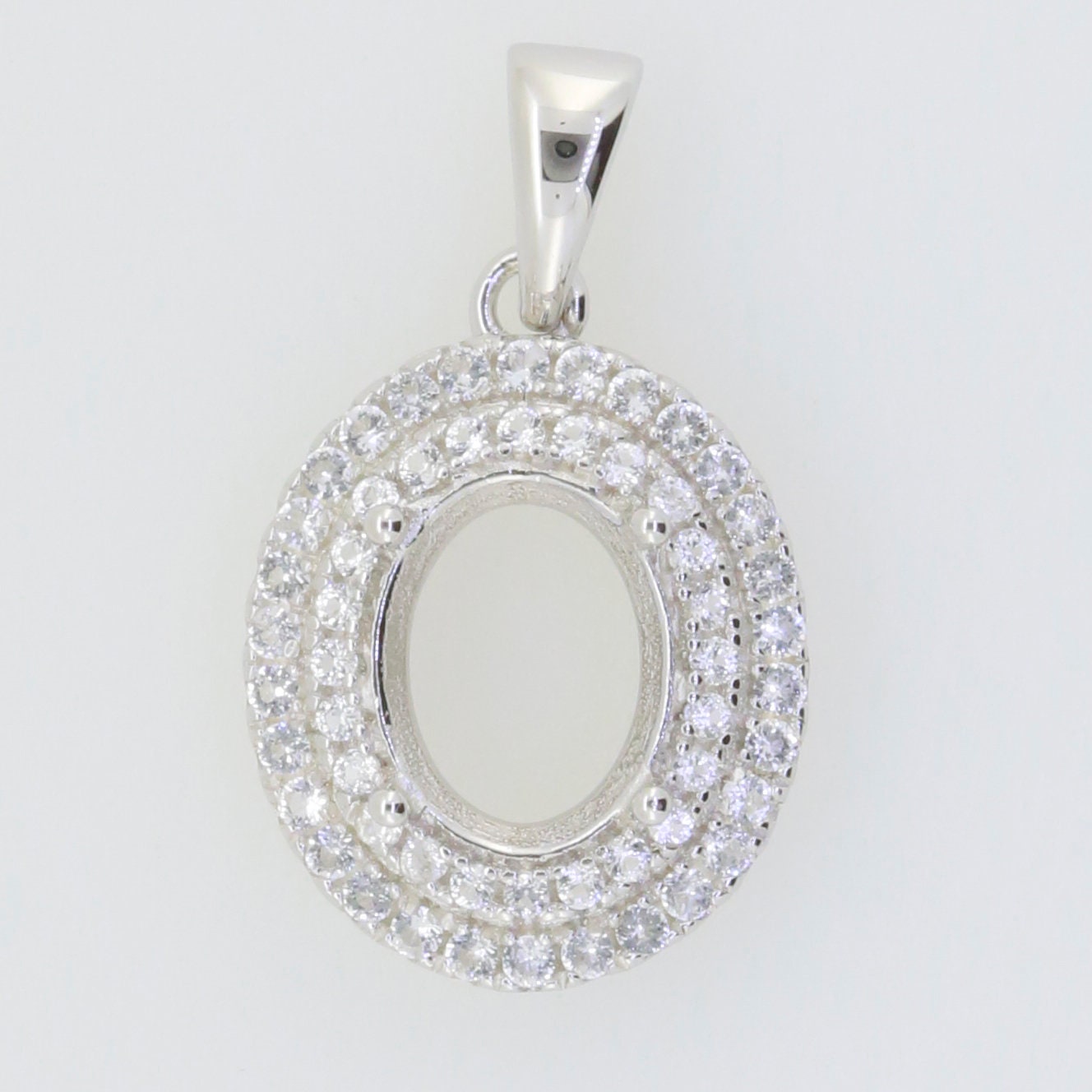 Sterling silver semi mount pendant setting oval with double halo of white topaz, crafted for custom gemstones.